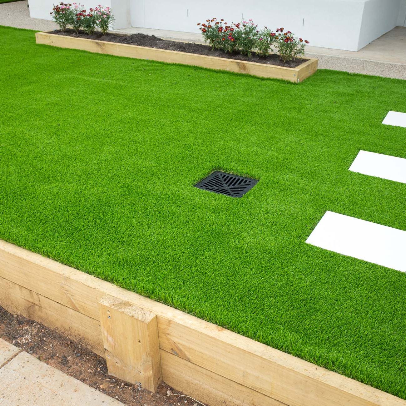 Artificial grass/lawn turf in the front yard of a modern home/residential house. Green fake grass at front garden